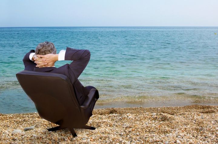 Mann auf einem Stuhl am Meer