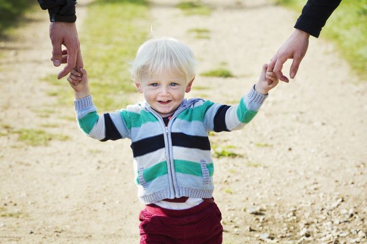 Der Junge geht mit Mama und Papa spazieren