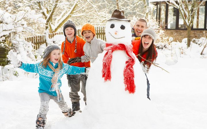 Familie formt einen Schneemann