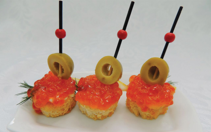 Ausgefallene Häppchen mit Oliven und rotem Kaviar für das neue Jahr 2020