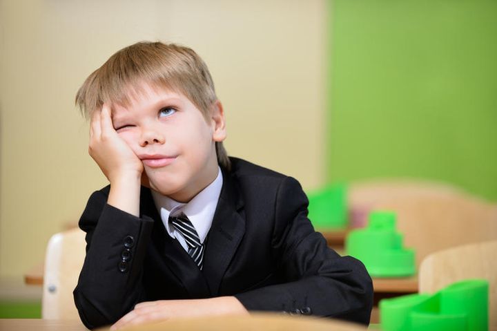 Schuljunge stützt seine Wange